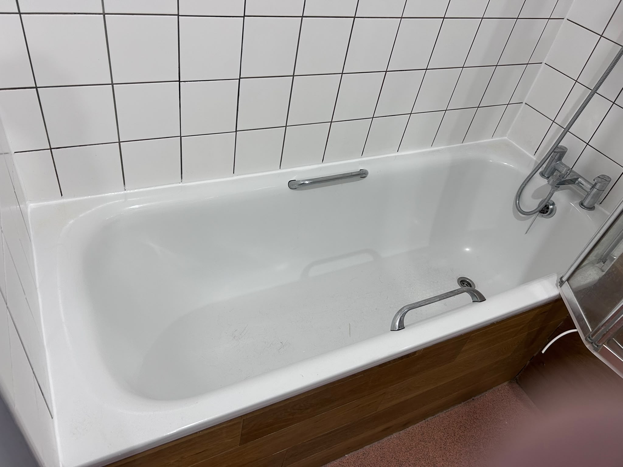 White bath with timber side panel