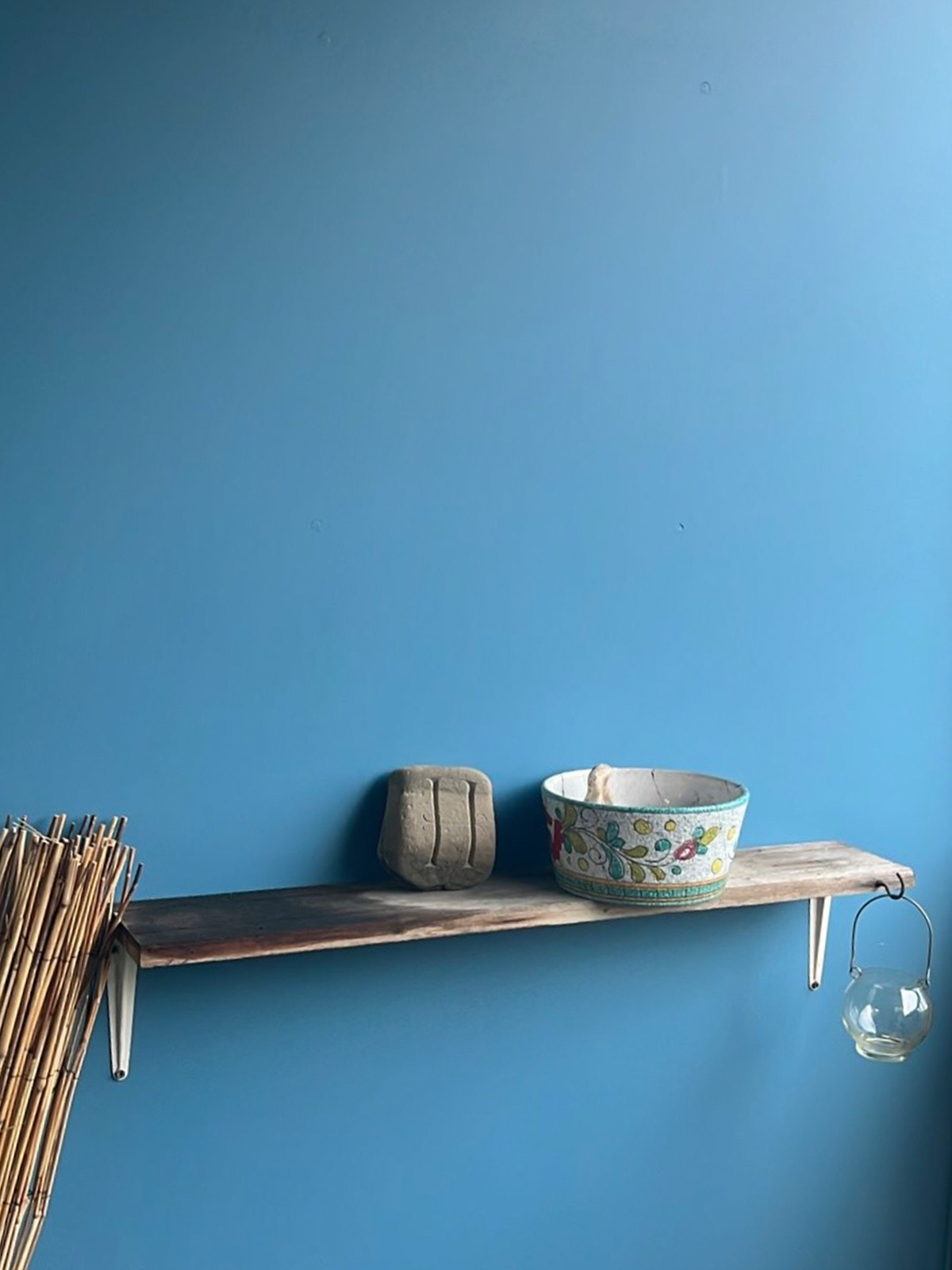 Blue painted wall with a wooden shelf